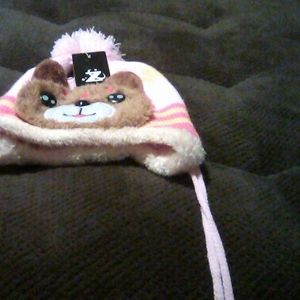 A pink and brown bear first hat